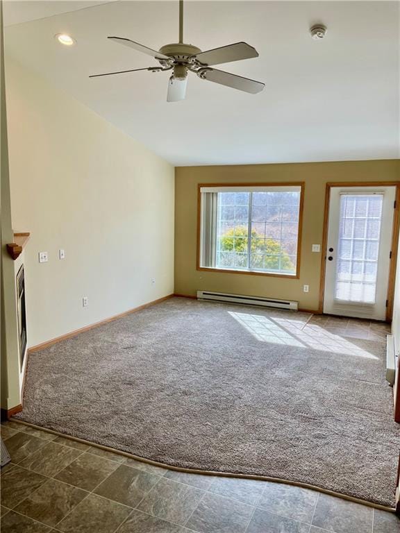 unfurnished living room with a baseboard heating unit, carpet, baseboards, and ceiling fan