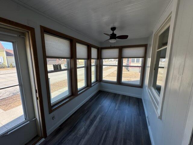 unfurnished sunroom featuring a ceiling fan