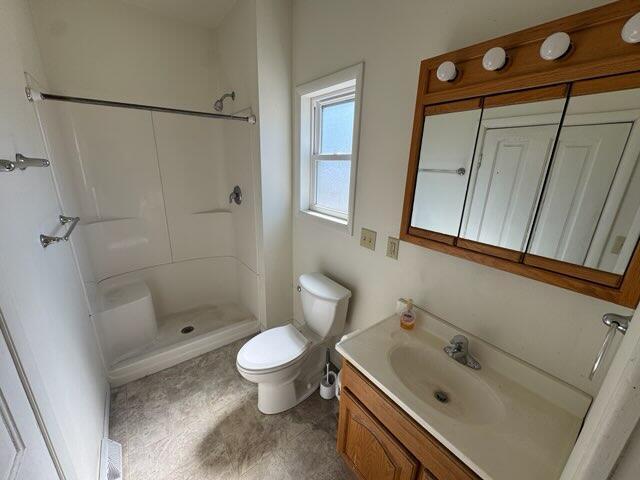 full bath with vanity, toilet, and a shower