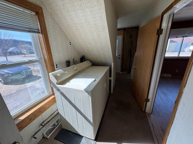 washroom with wood finished floors, visible vents, wallpapered walls, laundry area, and washing machine and dryer