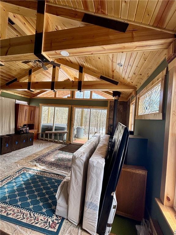 interior space with lofted ceiling with beams, wooden ceiling, and a wood stove