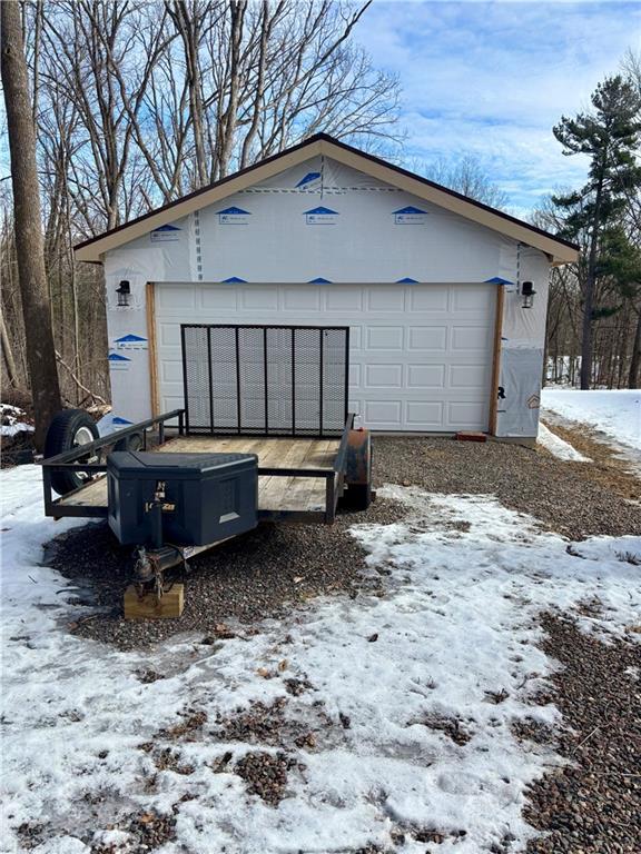 snow covered garage featuring a detached garage