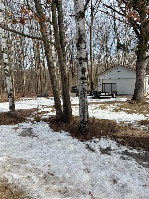 snowy yard featuring a garage