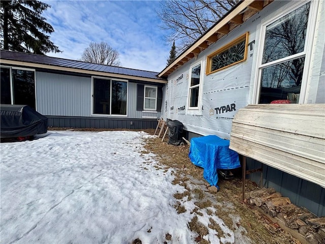 view of snow covered exterior featuring metal roof