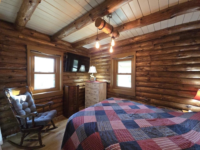 unfurnished bedroom featuring beam ceiling, wood finished floors, and wooden ceiling