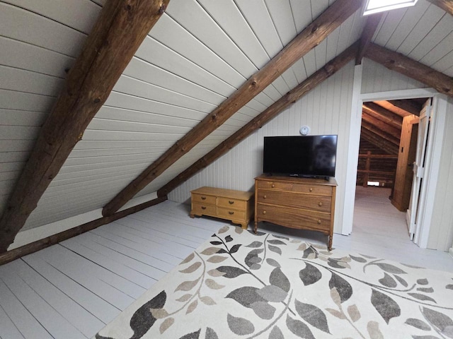 additional living space with wooden walls and vaulted ceiling with beams