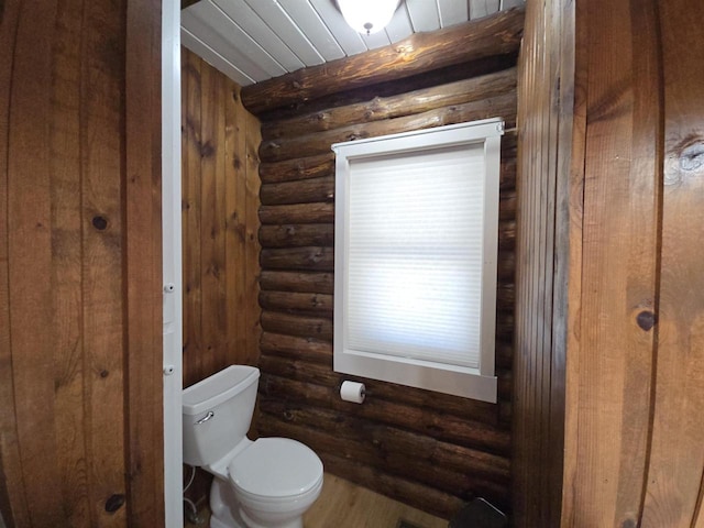 bathroom with rustic walls and toilet