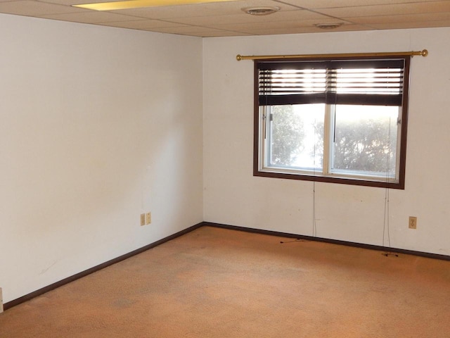 unfurnished room featuring a drop ceiling, baseboards, and carpet flooring