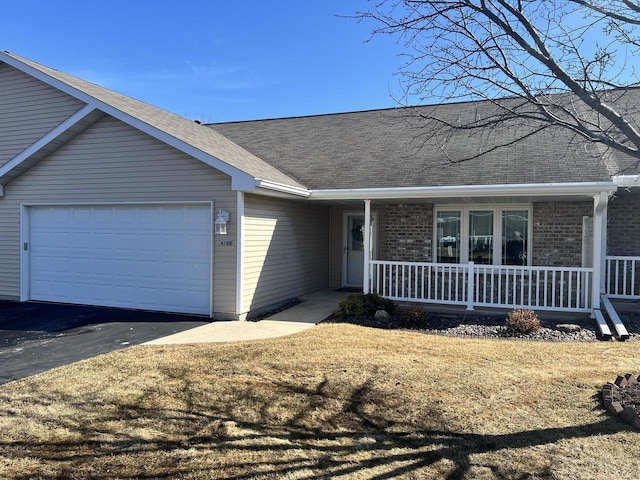 single story home featuring brick siding, a shingled roof, a porch, driveway, and an attached garage