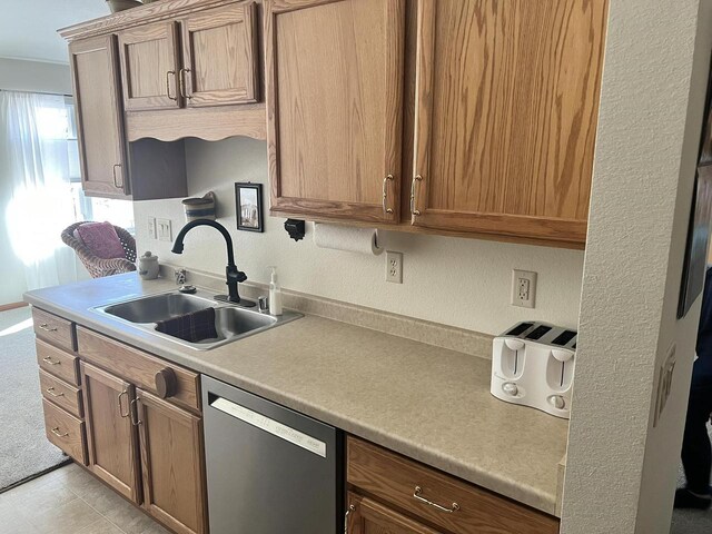 kitchen with dishwasher, light countertops, and a sink