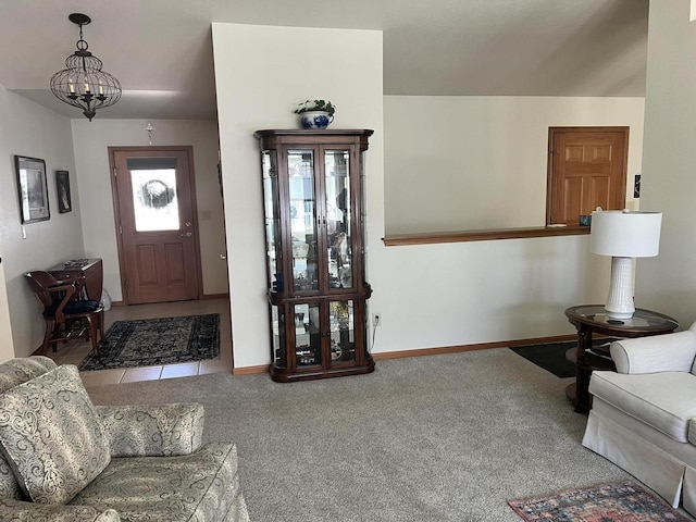 entrance foyer featuring an inviting chandelier, baseboards, and carpet floors