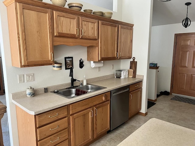 kitchen featuring dishwasher, light countertops, brown cabinets, and a sink