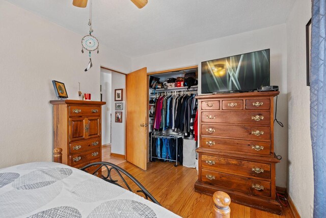 bedroom featuring light wood-style flooring, baseboards, a closet, and ceiling fan