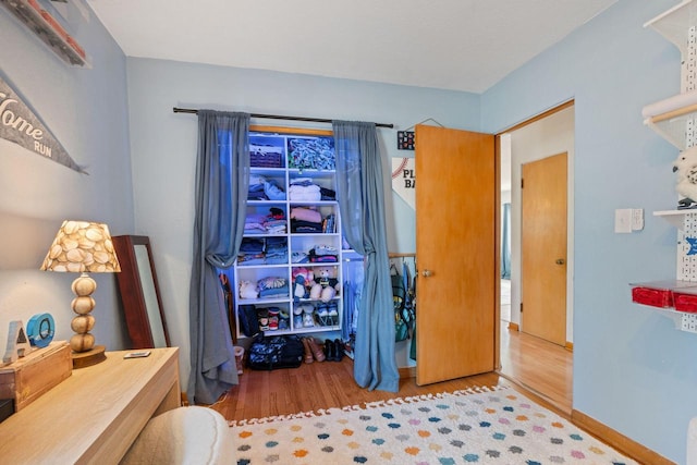 bedroom featuring baseboards and wood finished floors