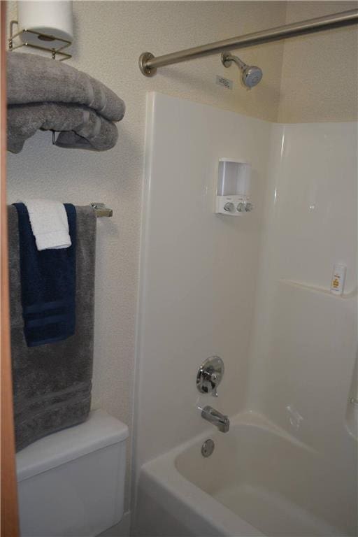 bathroom with toilet and bathtub / shower combination