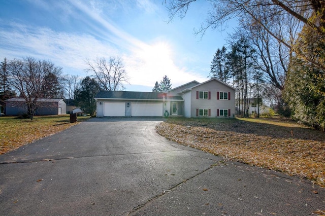 tri-level home with aphalt driveway and a garage