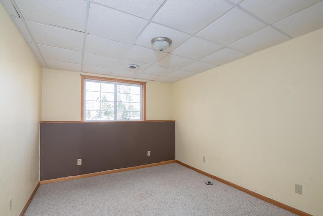 carpeted empty room featuring a drop ceiling, visible vents, and baseboards