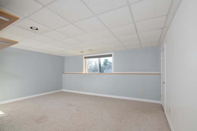 interior space featuring a paneled ceiling, baseboards, and carpet floors