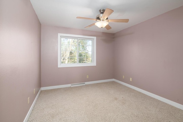 carpeted spare room with visible vents, baseboards, and ceiling fan