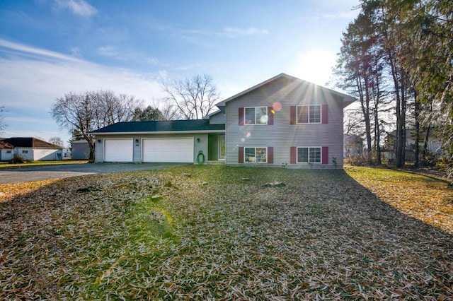 split level home featuring aphalt driveway and an attached garage