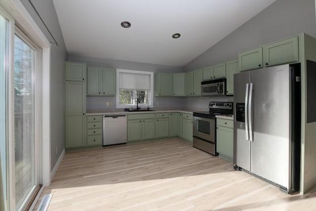 kitchen with stainless steel appliances, light wood-type flooring, lofted ceiling, and green cabinetry