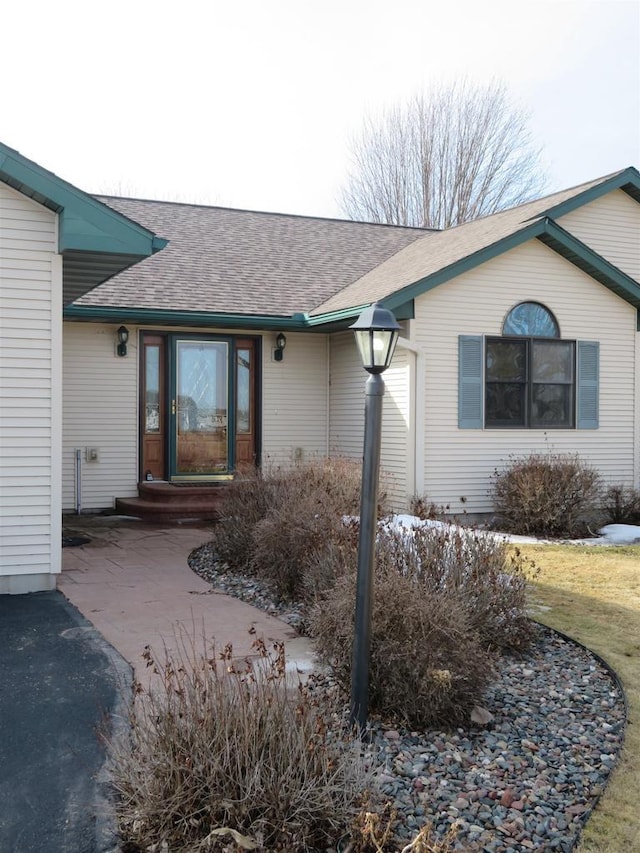 property entrance with a shingled roof