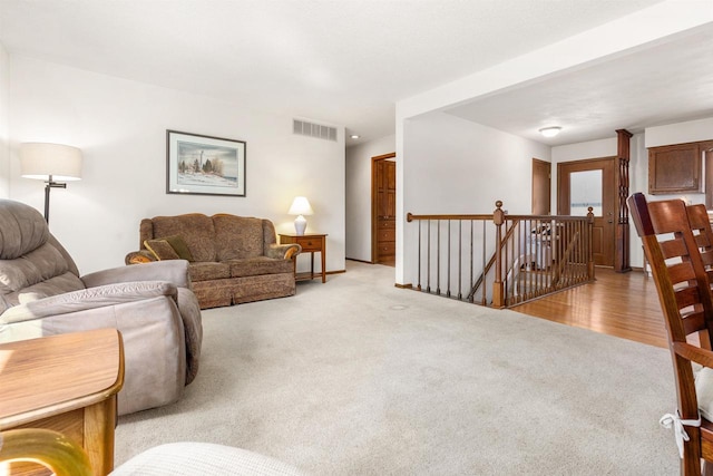 living area with visible vents and light colored carpet