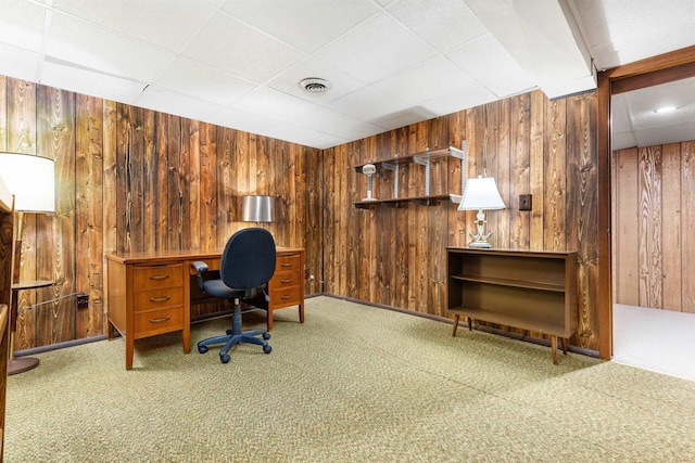 carpeted office space with visible vents and wood walls