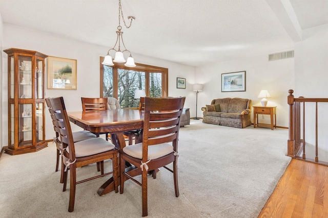 dining area with visible vents and light colored carpet