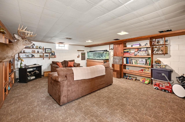 living area with concrete block wall and carpet floors