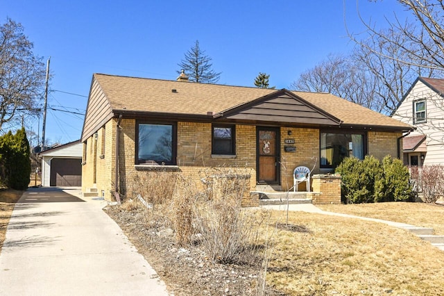 view of front facade featuring a garage, an outbuilding, roof with shingles, and brick siding