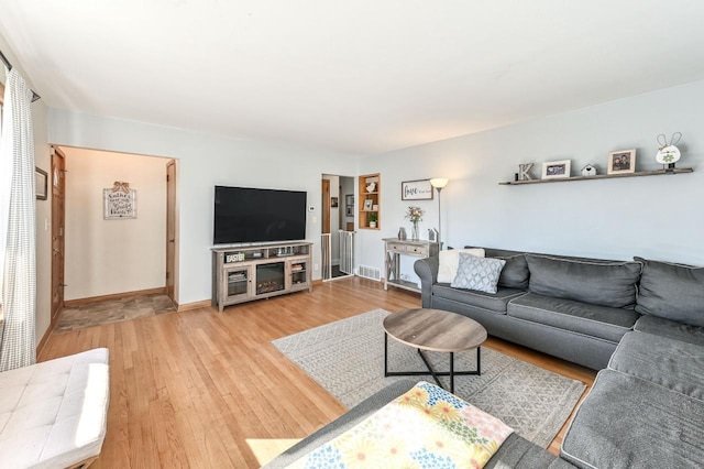 living area with baseboards and wood finished floors