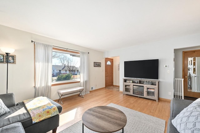 living area with baseboards and light wood-style floors