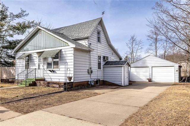 bungalow featuring a detached garage, roof with shingles, and an outdoor structure