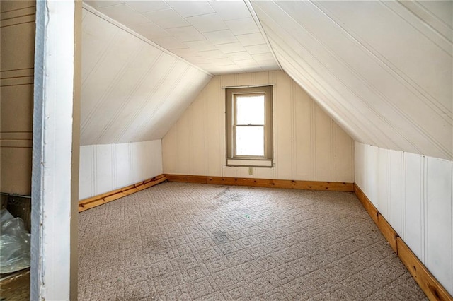 additional living space with carpet flooring and vaulted ceiling