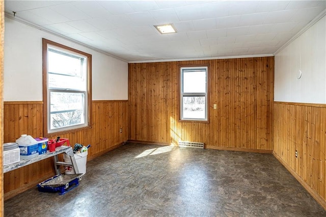 empty room featuring tile patterned floors, visible vents, wooden walls, and a wainscoted wall