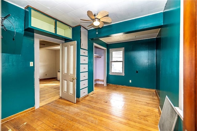 unfurnished room featuring baseboards, a ceiling fan, and hardwood / wood-style floors