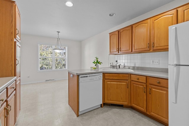 kitchen featuring visible vents, a sink, white appliances, brown cabinetry, and decorative backsplash