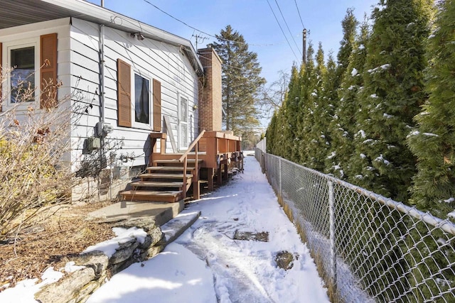 snow covered property featuring a fenced backyard