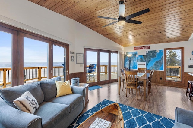 living room with a water view, wood finished floors, wooden ceiling, wainscoting, and vaulted ceiling