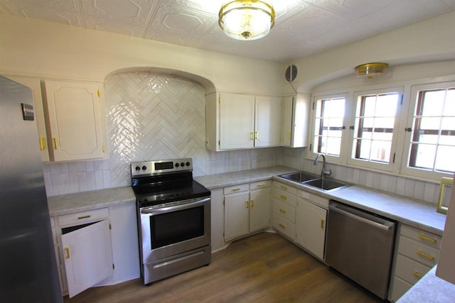 kitchen featuring a sink, an ornate ceiling, backsplash, white cabinetry, and appliances with stainless steel finishes