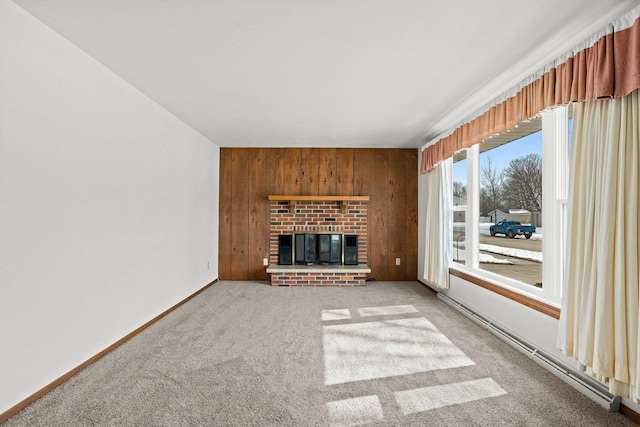 unfurnished living room featuring carpet, baseboards, a fireplace, wood walls, and a baseboard heating unit