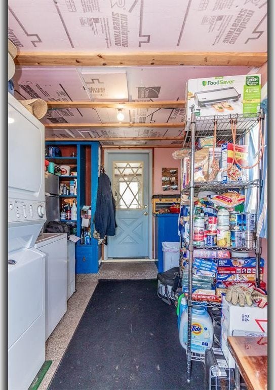 clothes washing area with laundry area and stacked washing maching and dryer