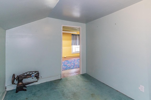 carpeted empty room with lofted ceiling