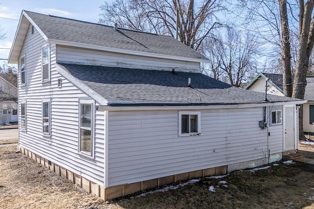 view of property exterior with a shingled roof