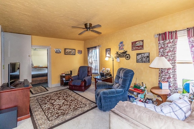 carpeted living room featuring a ceiling fan and a textured ceiling