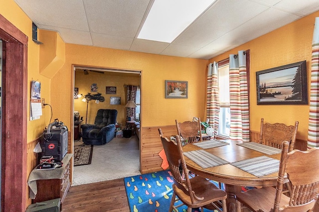 dining area with a paneled ceiling and wood finished floors