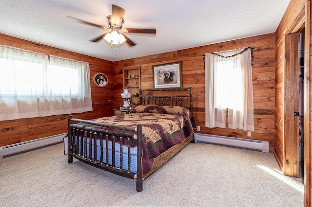 bedroom with multiple windows, carpet, and a baseboard radiator