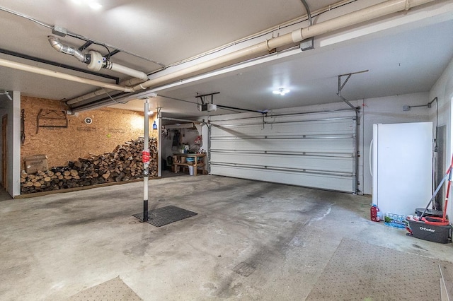 garage with a garage door opener and freestanding refrigerator