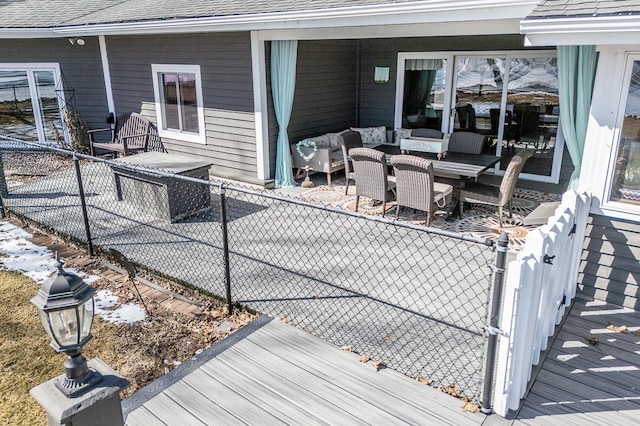 wooden deck featuring a patio, a gate, fence, outdoor dining area, and an outdoor hangout area